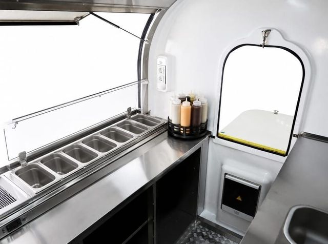 Saladerie-koeling met bakken en sausflessen in de foodtrailer
