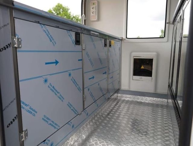 Lege werkruimte in de foodtrailer met kasten en traanplaatvloer