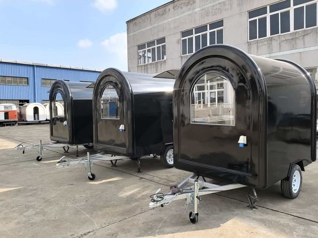 Drie onbedrukte zwarte foodtrailers bij de bouwer